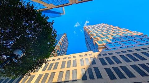 A photo of a large two-tower building under blue skies in Midtown Atlanta with many balconies and tall windows. 