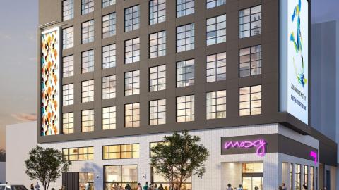 An image of a site where a large new white and black hotel is being built in downtown Atlanta near a wide street.