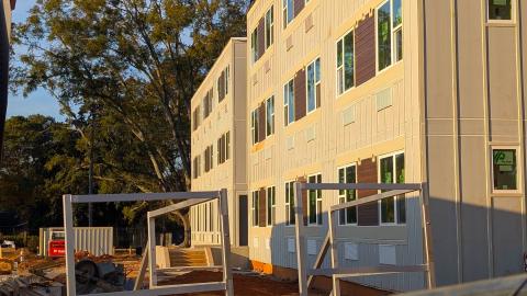 A photo of two new buildings made for shipping containers just west of Midtown Atlanta under evening fall skies made for homeless housing near a water reservoir.