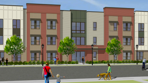 An image showing a large new brick and stucco building under blue skies in an Atlanta suburb, where an old apartment complex was demolished. 