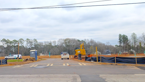 An image of a large clearing of woods for a big subdivision with trees and the edges and wide streets nearby, with a mall to the southeast.