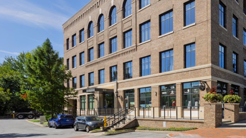 A photo of a large brick vintages-style building in suburban Alpharetta under blues skies north of Atlanta.