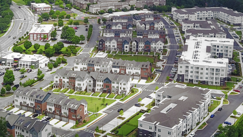 An overview image of a large section of townhomes and apartments in northern Atlanta near a wide road where a shopping center used to be.