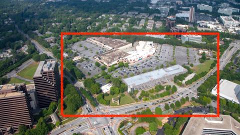 An overview of a large shopping center with big stores north of Atlanta near trees and many highways. 
