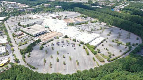 An aerial photo of a large dying mall in suburban Atlanta surrounded by many trees and wide streets. 