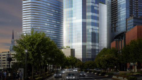 A rendering of a large two-tower office project along a wide busy street in Atlanta near a church with a tall steeple and many buildings. 