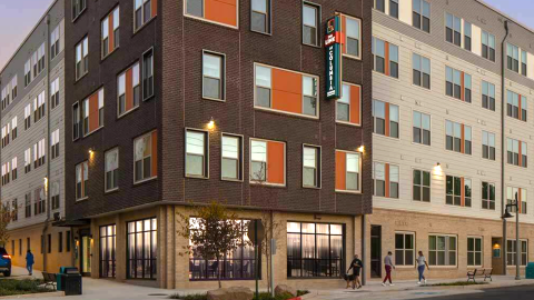 An image of a large brick and stucco apartment building under gray-blue skies east of Atlanta called The Link. 