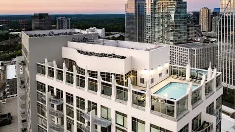 a pool area on top of a high-rise in the Peachtree Road section of Buckhead in Atlanta under blue-pink skies.