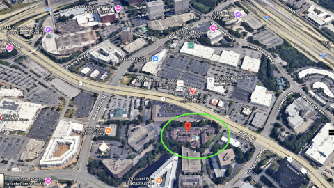 An overview of a large site where an old hotel will be bulldozed for a 300-unit hotel property surrounded by many businesses and large roads outside Atlanta. 