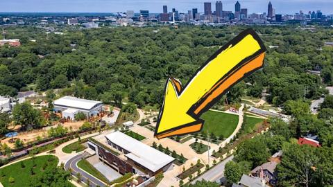A photo with an arrow and a large modern building in Atlanta near a huge park with many trees and a skyline. 