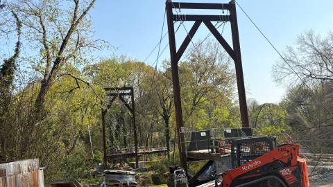 A large bridge over a creek in Atlanta that's being torn down now, under blue skies.