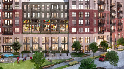 An image of a large apartment complex site in Atlanta along a wide street near trees and a warehouse retail district. 