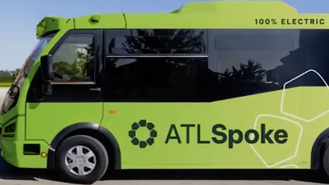 A photo of a lime-green driverless short bus under blue skies planned for a route in Atlanta near the Beltline.