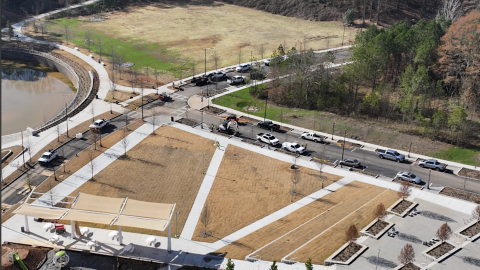An overview of a large development site south of downtown Atlanta near many trees and a new park with open lots nearby. 