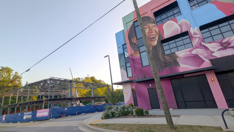 A photo of Two new components taking shape at Southeast Atlanta project along Moreland Avenue near many trees and an existing building covered in murals.