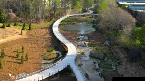 An image of a large concrete trail system through woods and a new boardwalk in a suburban city north of Atlanta.
