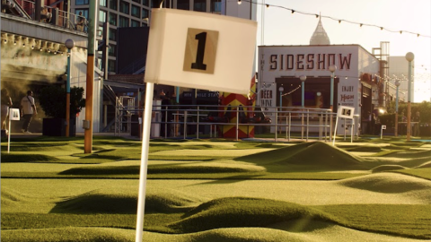An image of a mini golf course on top of a huge brick building with skyline views in Atlanta.