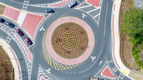 A large highway and street project northwest of Atlanta with large roundabouts and a new bridge spanning a highway over Interstate 75, with many trees around it.