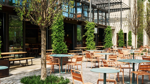 A photo of a large retail space patio near many trees and tables with blue and orange interiors in Atlanta.
