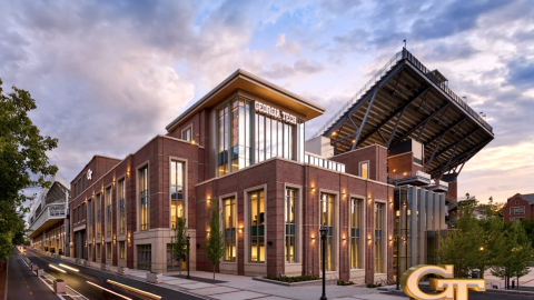 a large modern stadium expansion project with large interiors and a brick facade under blue skies and clouds called Georgia Tech Thomas A. Fanning Student-Athlete Performance Center