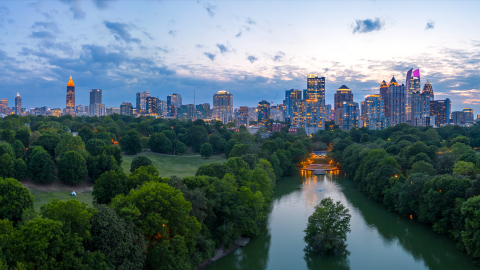 An image of a large city next to a huge green park under blue evening skies. 