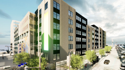 An image of a large senior housing project near Underground Atlanta and wide street and tall buildings linked to an existing parking deck.