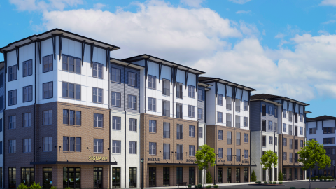 An image showing a site where a large mixed-use development is underway near a winding highway and interstate and shopping centers.