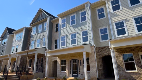 A photo of a large traditional townhome development in Gwinnett County, Georgia under blue skies.