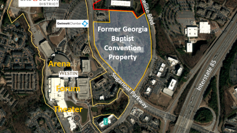 An image of a large office complex in suburban Atlanta near a wide interstate and many buildings and trees.