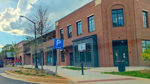 A photo of a large new brick building under blue skies and many clouds near Atlanta.