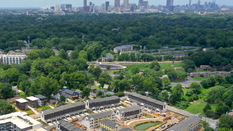 An aerial photo overview of a large new construction project in Atlanta near a wide trail and many trees and streets.