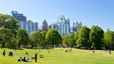 An image of a large park in Atlanta with many trees and tall buildings around it.