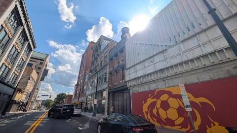 A photo of a large street with old building some vacant some rehabbing under a blue sky with clouds in downtown Atlanta.