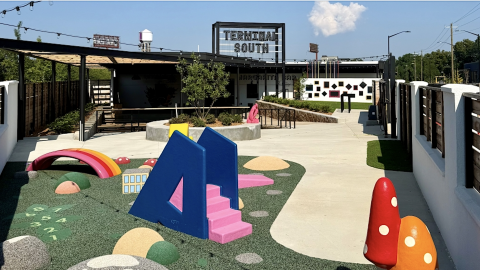 A new warehouse district under blue skies with a wedge-shaped playground near a wide parking lot in Atlanta.