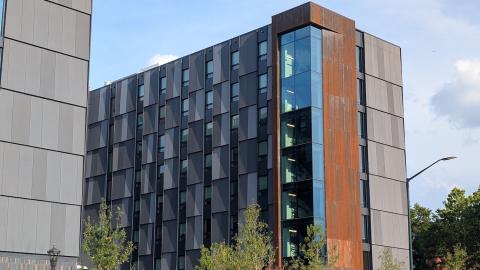 Image of modern-style new dorm buildings with gray paneling and steel cladding under blue skies in Atlanta.