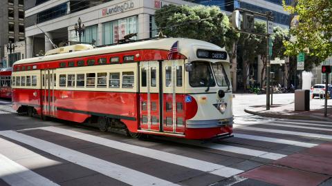 An image of a throwback-style streetcar on a large and wide American street.