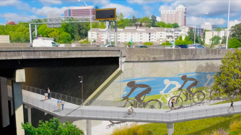 An image of a large new multi-use trail planned in Atlanta under an interstate near many large buildings.