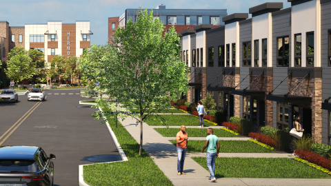 An image of a large new apartment complex near downtown Atlanta with green lawns and a wide street, with many buildings.