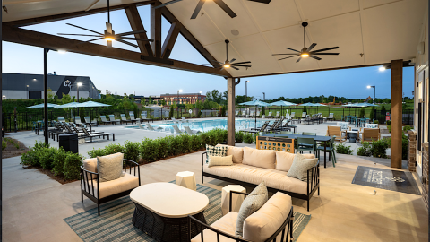 An image of a large new apartment complex with a pool and gym and contemporary interiors.