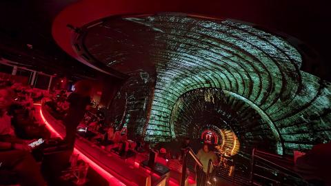 An image of a large shared-reality attraction in downtown Atlanta with a huge screen near many tall buildings and businesses.