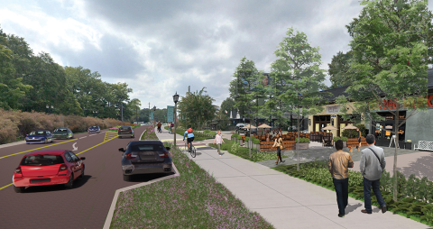 An image of a wide highway running through a city with many trees on either side.